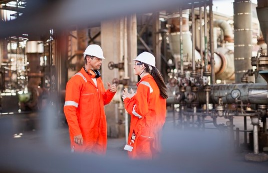 Workers talking at oil refinery