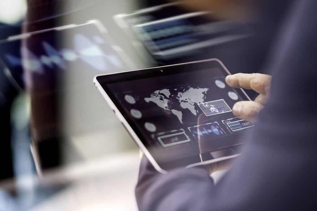 Close-up photo of a caucasian businessman's hand while using a digital tablet.